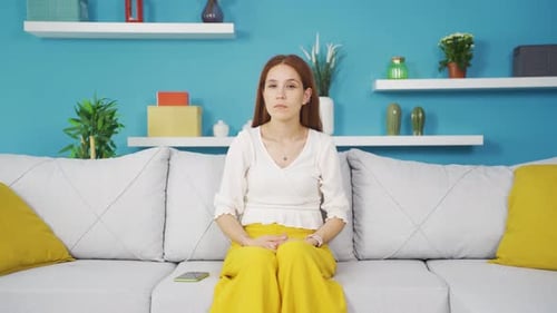 Thoughtful Woman Sitting on Couch Thinking