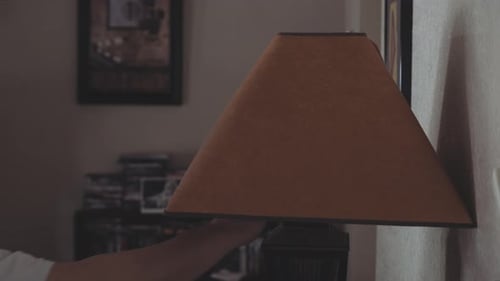 Close up of a man’s hand turning on and off table lamp