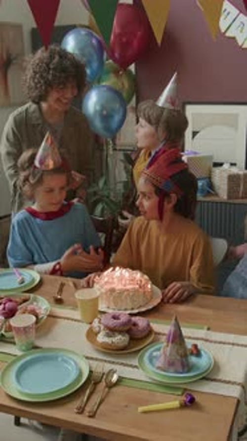 Boy Blowing Candles on Birthday Cake, Surrounded by his Friends