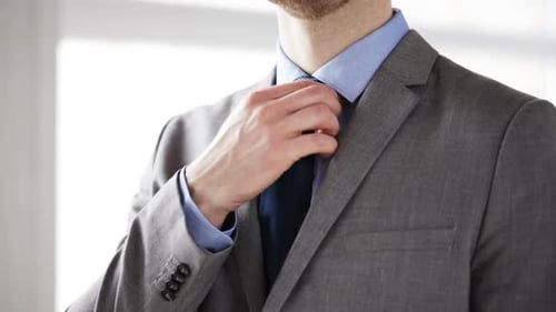 People, Business, Fashion And Clothing Concept - Closeup Shot Of Man In Suit Adjusting Necktie At...