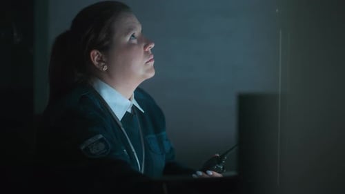 Female Dispatch Uses Walkie Talkie Sitting in Monitoring Center
