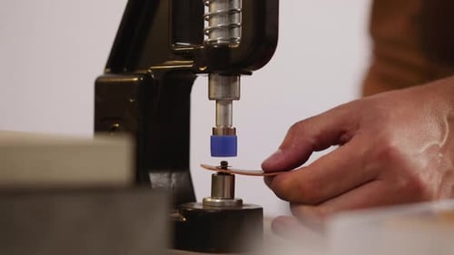 Master Installs Rivet in Leather with Machine in Workshop