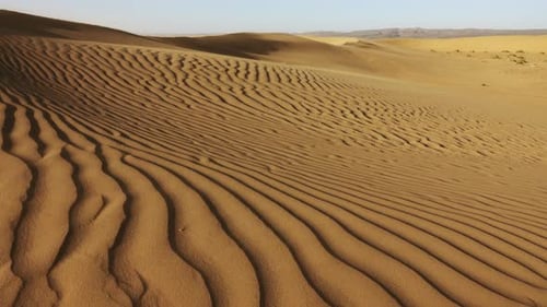 Sand weht im Wind über Sanddünen
