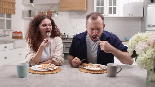 Couple Enjoying a Delicious Meal in Bright Kitchen