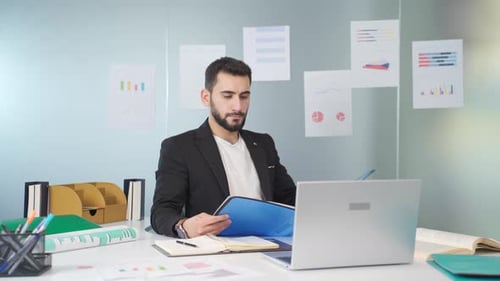 Man Reads Documents at Bright Office Desk
