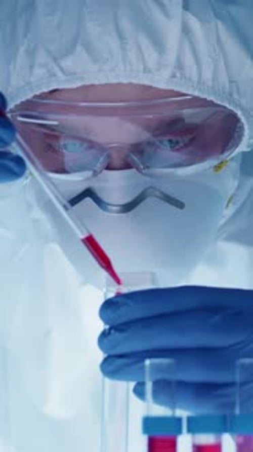 Close-up of Male Scientist Filling Test Tube with Red Substance