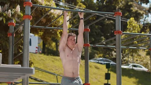 Man Doing Leg Raises on Pull Up Bar Outdoors