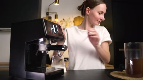 Woman Makes Espresso at Home on Modern Machine