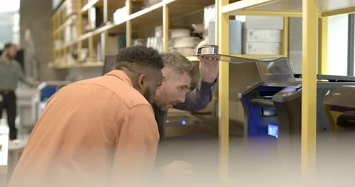 Engineers in creative office looking at 3d printer and model