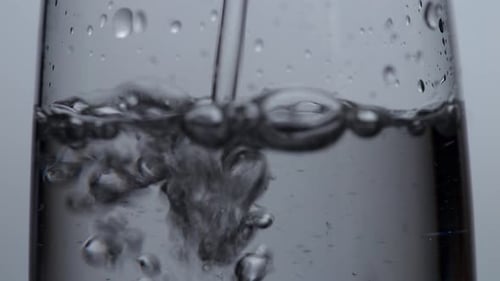 Close Up Of Drinking Water Being Poured Into A Glass On The Light White Screen Background