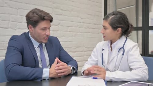 Female Doctor Talking with Middle Aged Man