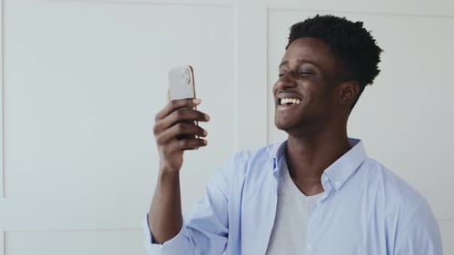 Man Laughing on Phone Video Chat Indoors