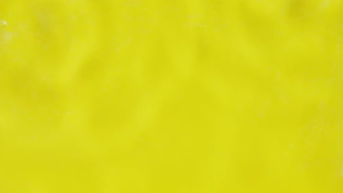 Multiple Water Drops Falling on Water Surface Making Multiple Water Circles on Yellow Background