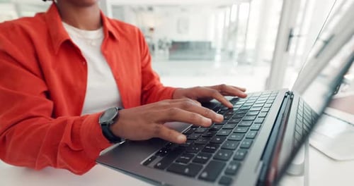 Woman Typing on a Laptop in an Office