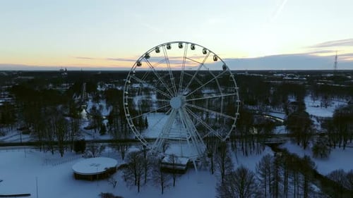 Ferris Wheel in Victory Park Riga at Sunset During Winter Snow Landscape