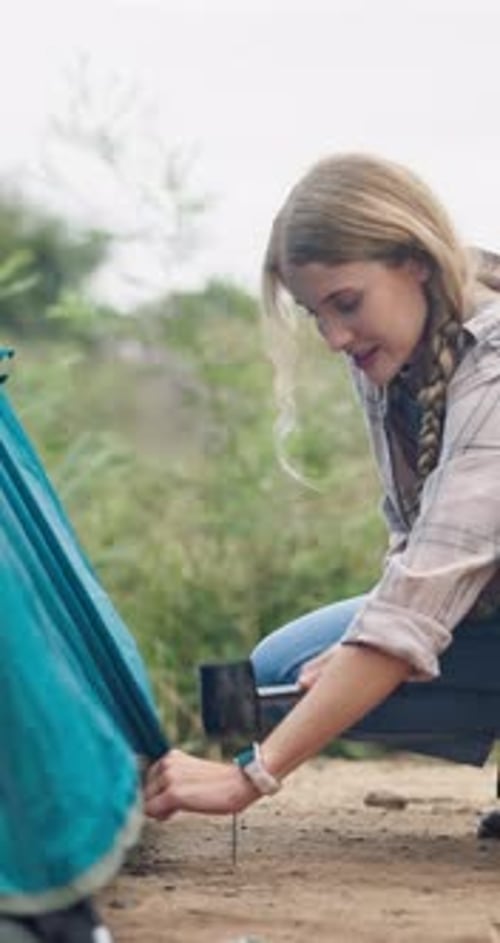 Woman, tent and setup with peg in nature for camping preparation or secure outdoor shelter