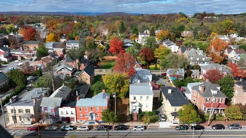 Small town America in autumn. Aerial truck shot of houses and homes lining street in suburban neighb