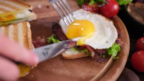 Cutting Open Fried Egg on Delicious Sandwich