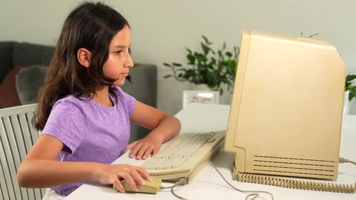 Hispanic Kid Girl Typing o Vintage Computer Keyboard and Moving Mouse. 90s 80s Technology Concept