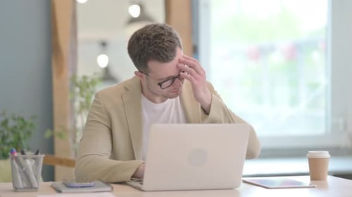 Young Adult Working on Laptop with Headache
