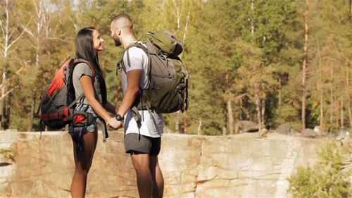Young Couple of Hikers Kisses Near the Cliff