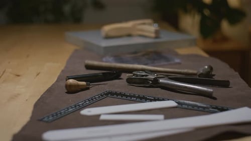 Outils de maroquinerie disposés sur un établi avec des instruments de précision