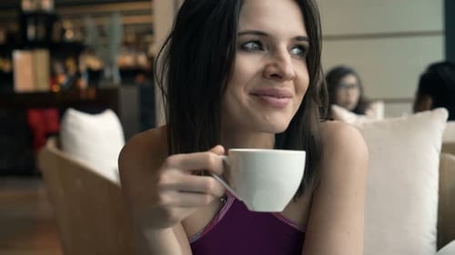 Happy brunette woman enjoying tasty coffee latte at cafe