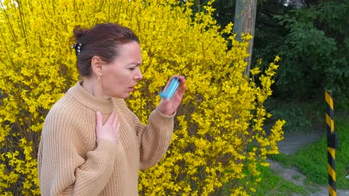Woman With Asthma Uses Inhaler Outdoors