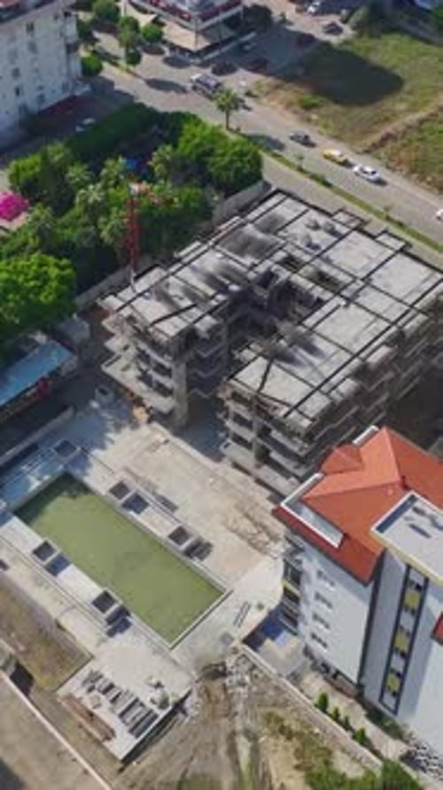 Vídeo vertical: corte de piedra, instalación de fachadas y montaje de estructuras metálicas en una construcción muy transitada