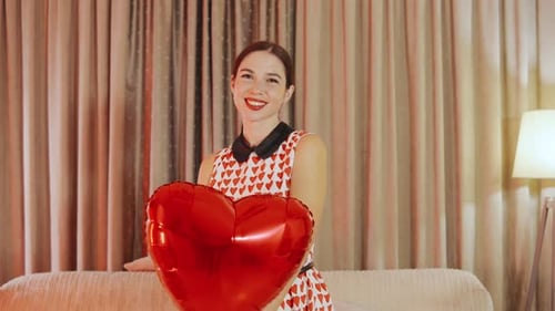 Smiling Young Woman Posing with Heart-Shaped Balloon