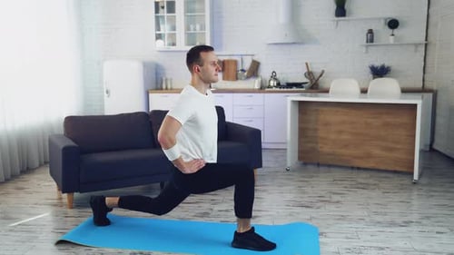 Athletic Man Doing Lunges in Modern Apartment