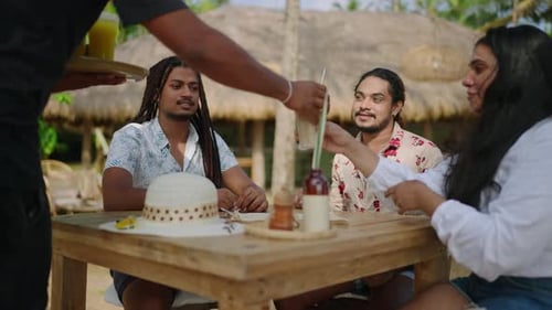Diverse LGBTQ Friends Enjoy Brunch at Tropical Outdoor Cafe Group Laughs Shares Drinks Under
