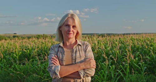 Smiling Woman Standing in Field of Ripening Corn