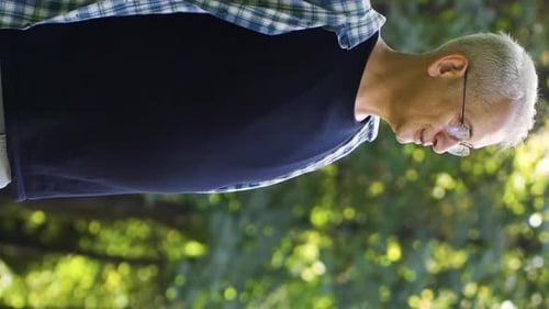 Vidéo verticale de L'homme suffoque à cause du temps chaud et ensoleillé à l'extérieur.
