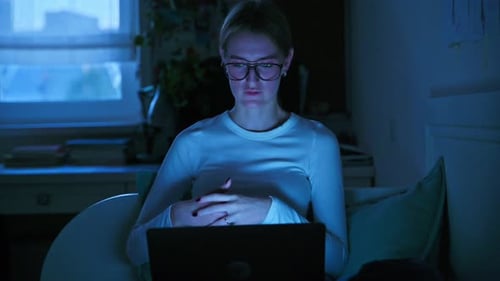 Woman Using Laptop at Night in Home