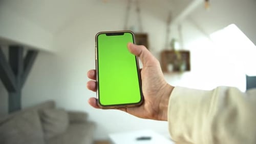 Hand Holding Smartphone With Green Screen Display