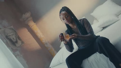 Young Adult Inspecting Perfume Bottle Indoors