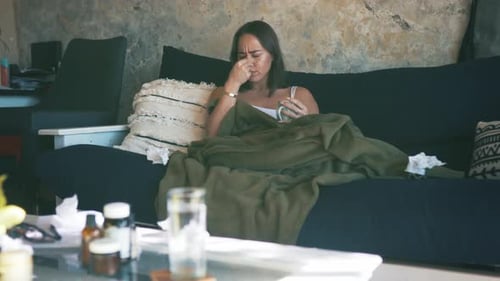 Young Woman Lying on Couch Feeling Sick