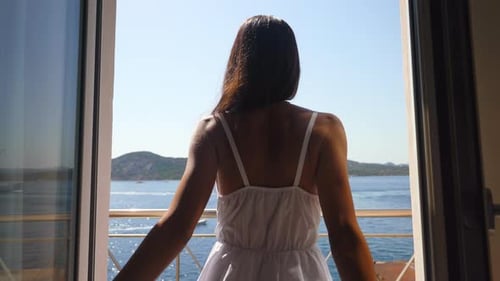 Authentic shot of an young woman is enjoying a panoramic view on a sea with yachts from a terrace