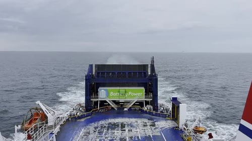 Blick auf das Ende einer Autofähre, die unter bewölktem Himmel über das Meer fährt, blau-weißes Schiff