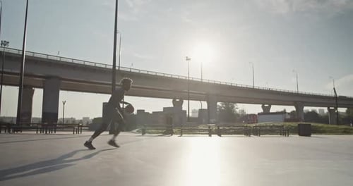 Man Playing Basketball and Slam Dunking Outdoors