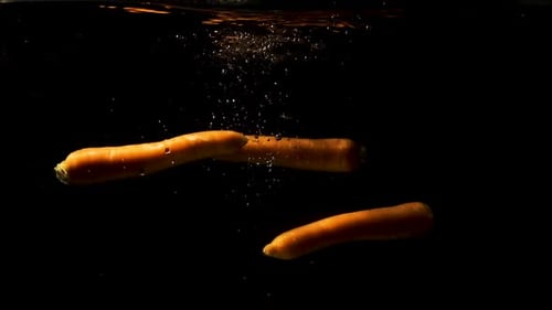 A Fresh Carrots Drop Beneath The Water - Medium Shot