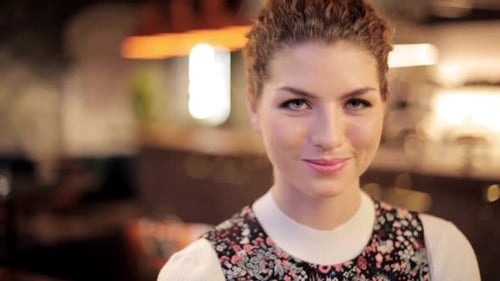 Smiling Young Woman Looking at Camera in Restaurant