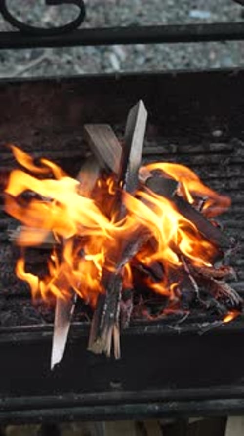 Feuerbrennender Holzgrill aus Metall zum Grillen, Lagerfeuer, vertikales Video