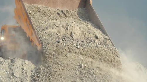 Dump Truck Unloading Rocks and Soil at Construction Site