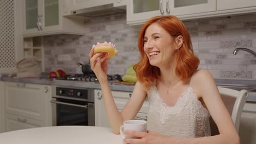 Woman Shares Donut in Bright Kitchen