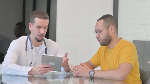 Doctor Explains Information to Patient Using Tablet
