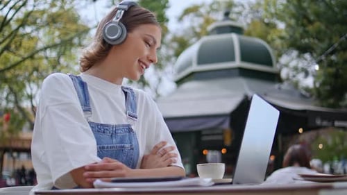 Friendly Lady Talking Online Meeting By Laptop Sitting Cafe in Earphones Closeup