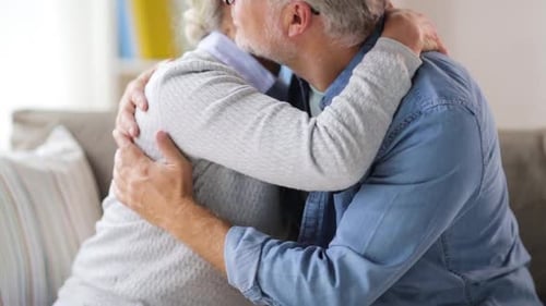 Loving Senior Couple Embracing Tenderly on Sofa