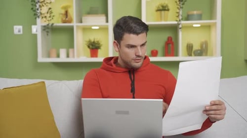Man Works on Laptop at Home on Couch